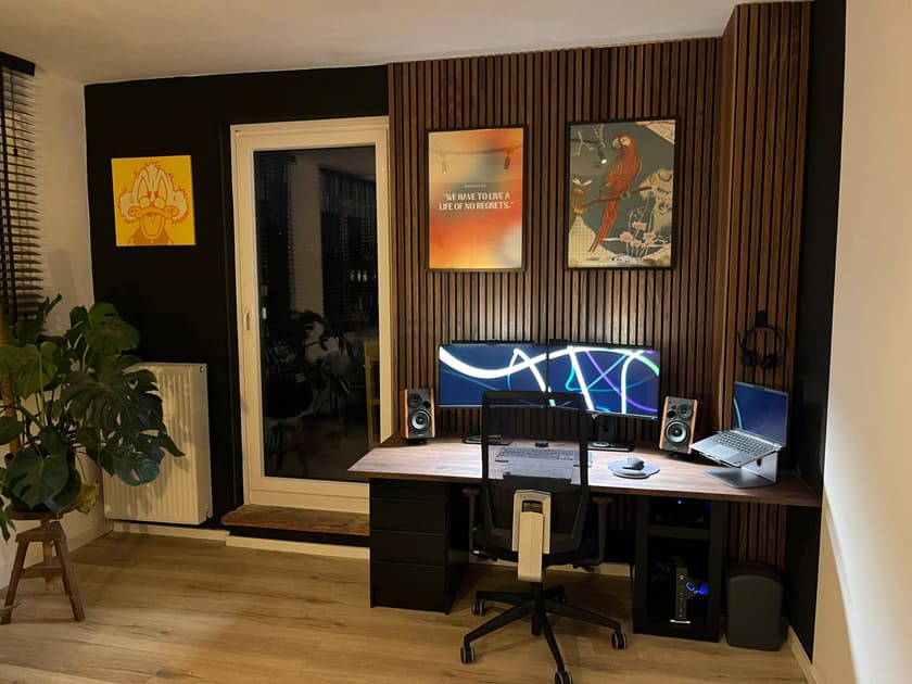 Arbeitszimmer mit montierten Akustikpaneelen und Schreibtisch mit massiver Arbeitsplatte.