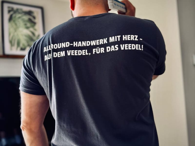 Rückenaufdruck des Arbeitsshirts: Allround-Handwerk mit Herz – aus dem Veedel, für das Veedel!